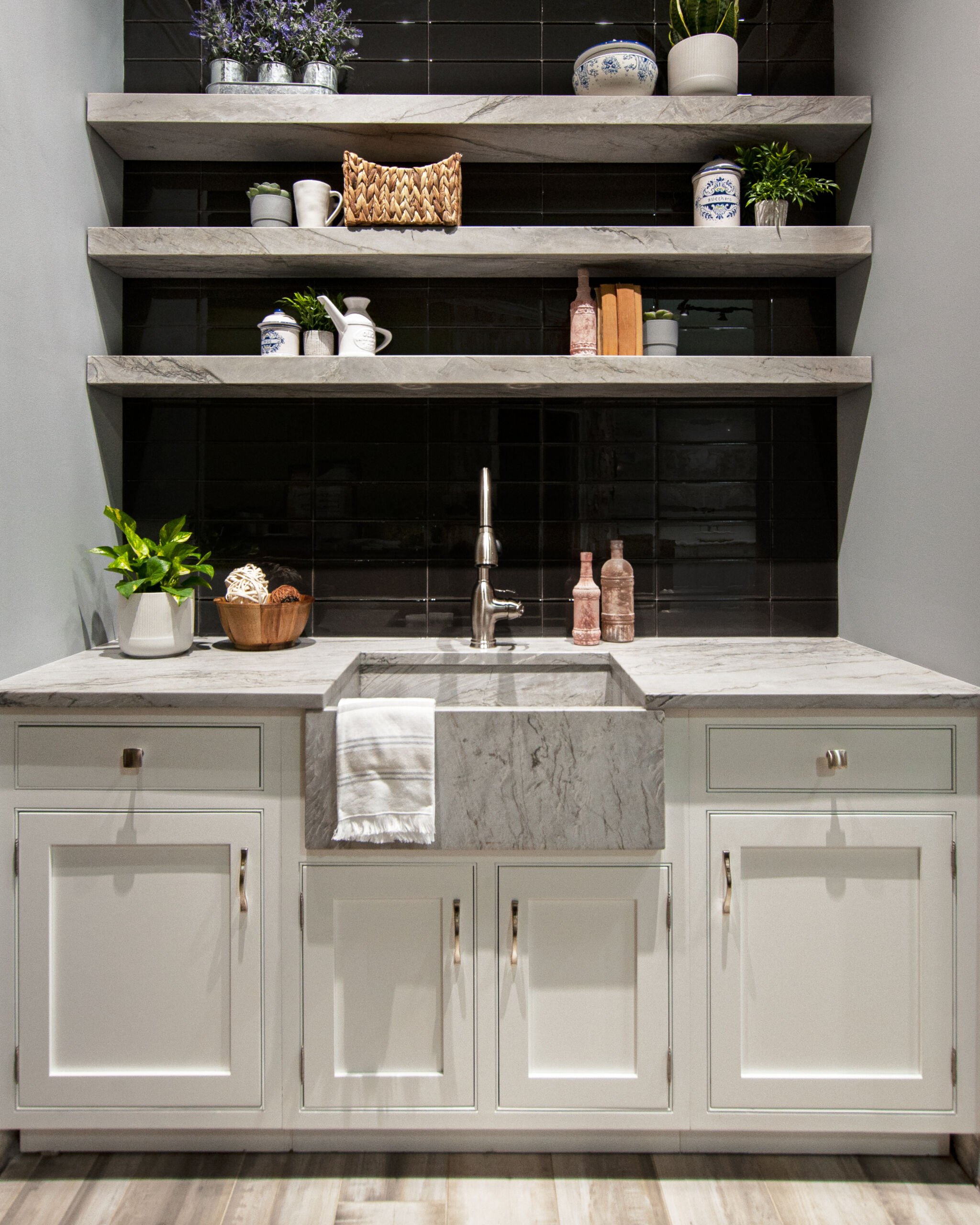 Modern kitchen with white cabinetry, large island, and light stone countertops