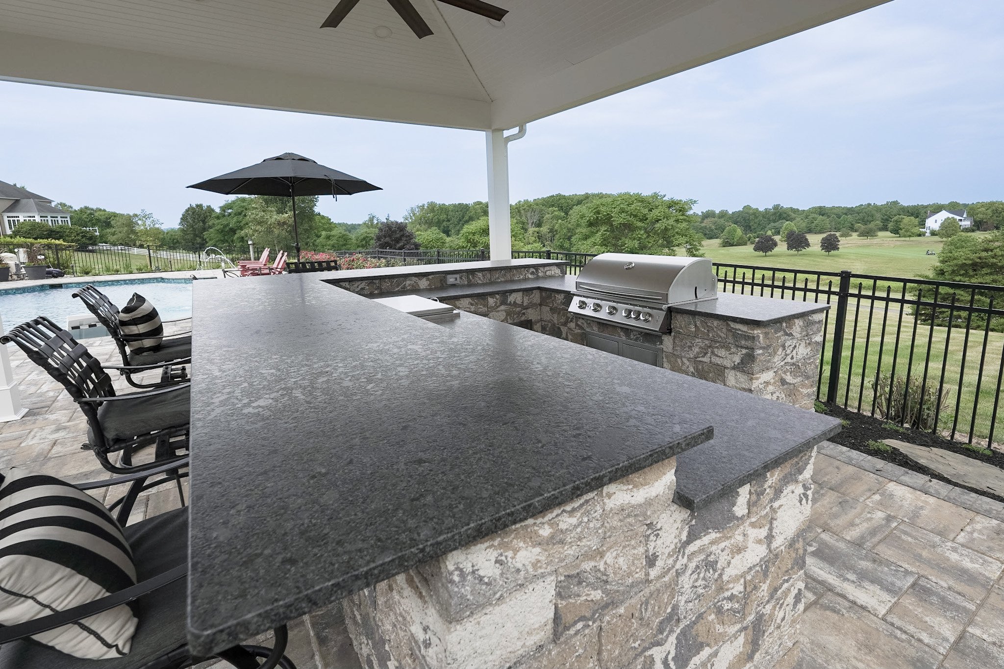 Outdoor kitchen with steel gray granite countertop and built-in appliances